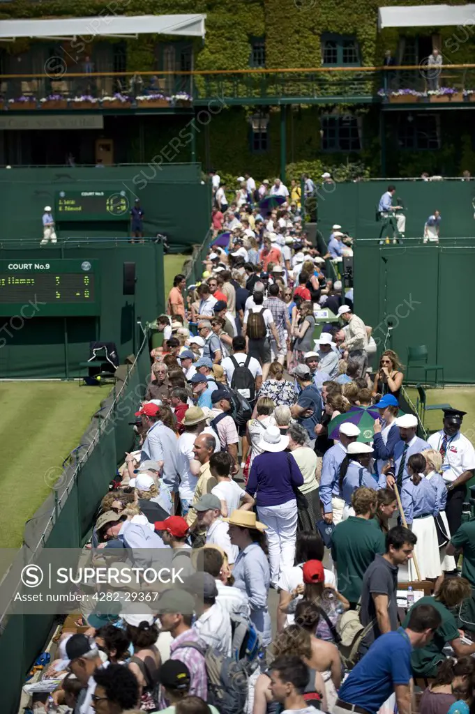 England, London, Wimbledon. Crowds line the gangways between the outside courts at the 2011 Wimbledon Tennis Championships.