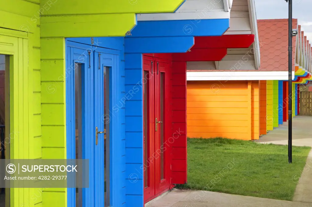 England, North Yorkshire, Scarborough. Traditional colourful beach chalets located on the North Bay promenade.