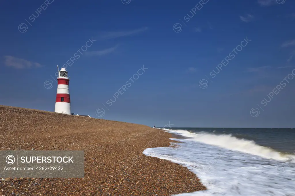 England, Suffolk, Orford Ness. Waves rolling on to the shingle beach by Orfordness Lighthouse.