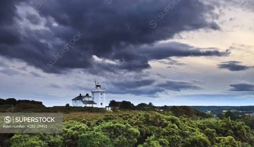 England, Norfolk, Cromer. Storm clouds moving over Cromer Lighthouse, an octagonal tower that first came into operation in 1833, on a summers evening.