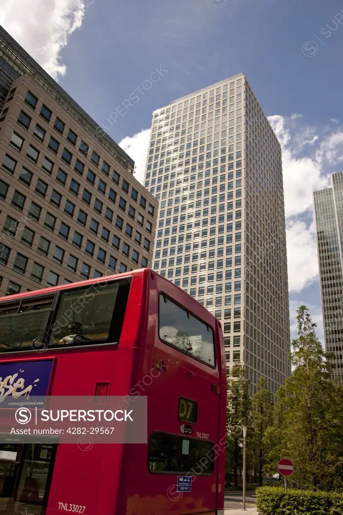 England, London, Canary Wharf. Red London double decker bus travelling through the new financial district at Canary Wharf.