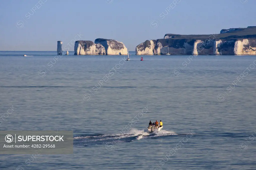 England, Dorset, Poole. People aboard a speed boat heading towards Old Harry Rocks, two chalk sea stacks on the Isle of Purbeck.