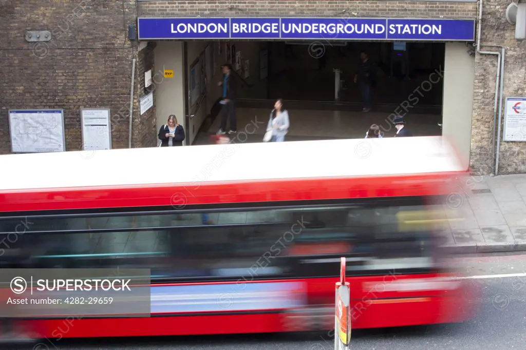 England, London, London Bridge. A red London bus passing an entrance to London Bridge Underground Station.
