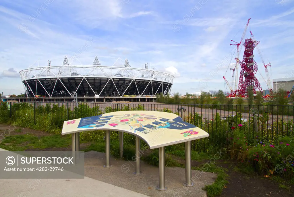 England, London, Stratford. The London 2012 Olympic stadium, the ArcelorMittal Orbit observation tower and site map in the Olympic Park in Stratford in the east end of London.