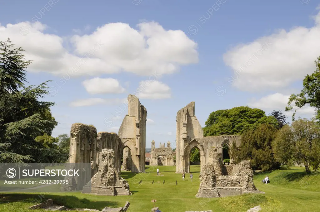 England, Somerset, Glastonbury. Tourists strolling amongst the ruins of Glastonbury Abbey, the legendary burial place of King Arthur.