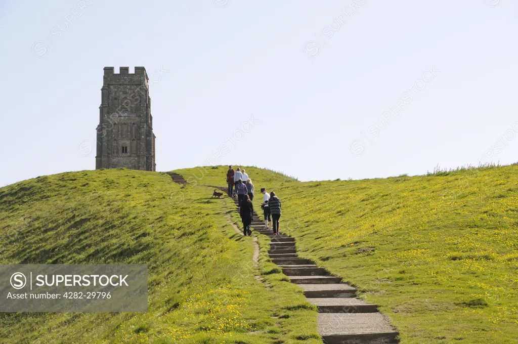 England, Somerset, Glastonbury. Tourists climbing the path to Glastonbury Tor to St. Michael's Tower.