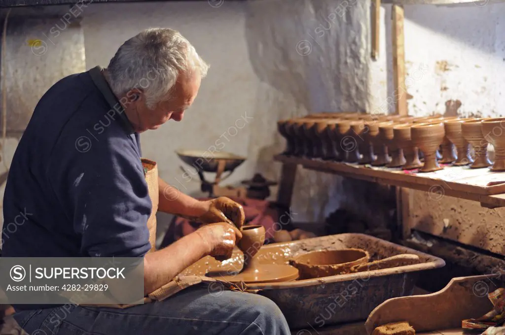 England, Cornwall. Potter turning traditional clay goblets.