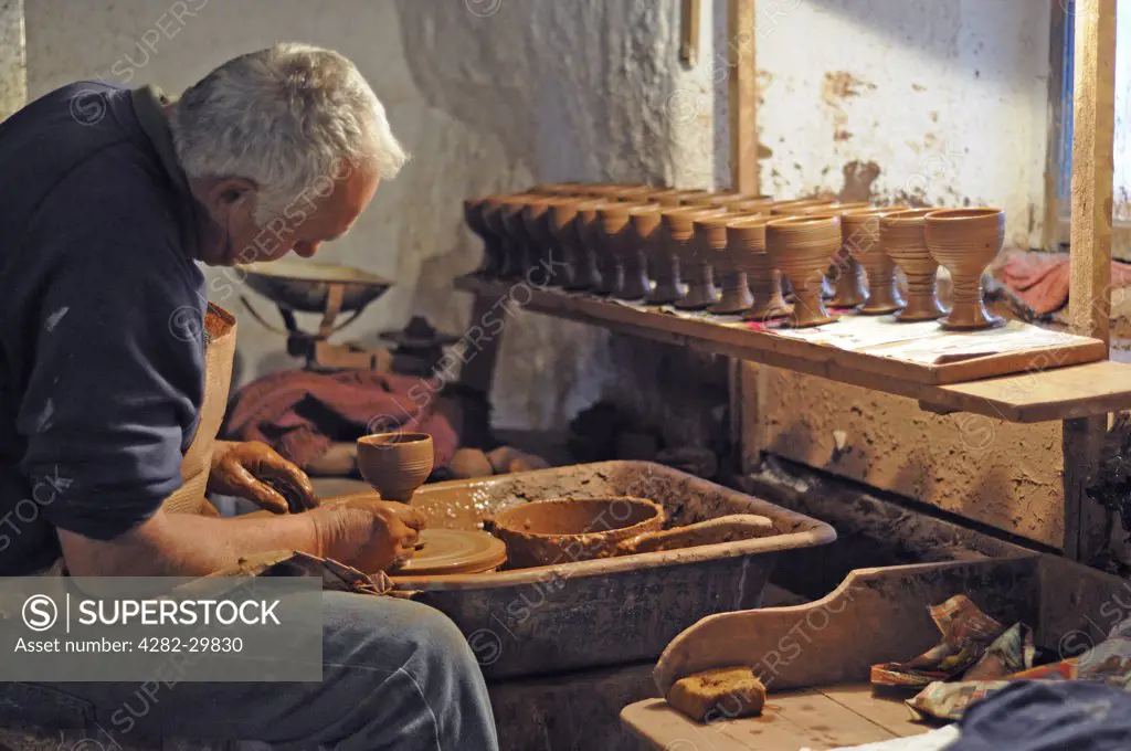England, Cornwall. Potter turning traditional clay goblets.