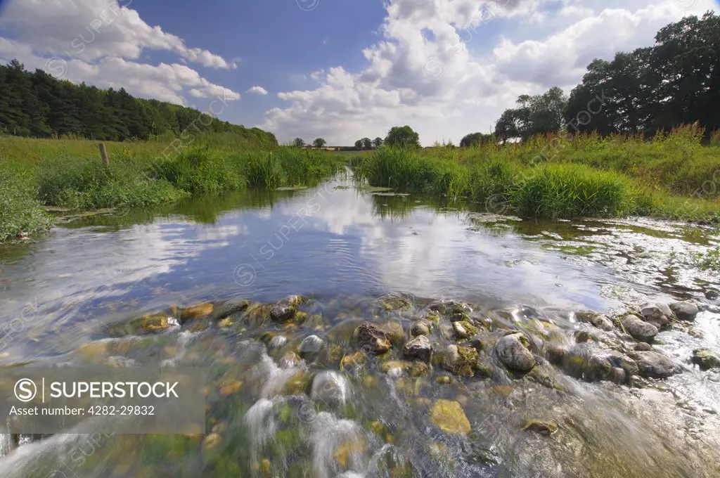 England, Norfolk, River Stiffkey. Water flowing over small rocks in the River Stiffkey.