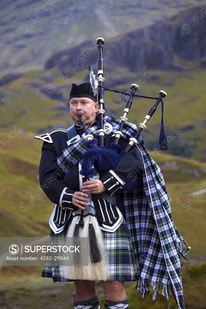 Scotland, Highland, Glen Coe. A Scottish piper playing the bagpipes in Glen Coe.