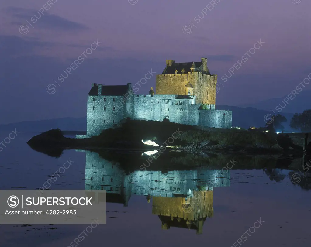 Scotland, Highland, Dornie. Reflections in the water at of an illuminated Eilean Donan Castle.