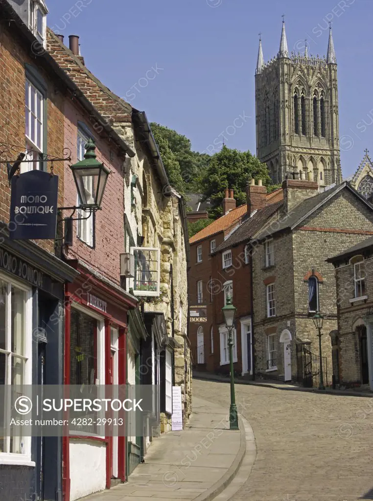 England, Lincolnshire, Lincoln. Medieval buildings line the cobbled street and flagstoned pavement leading to the cathedral quarter at the top of Steep Hill in Lincoln.