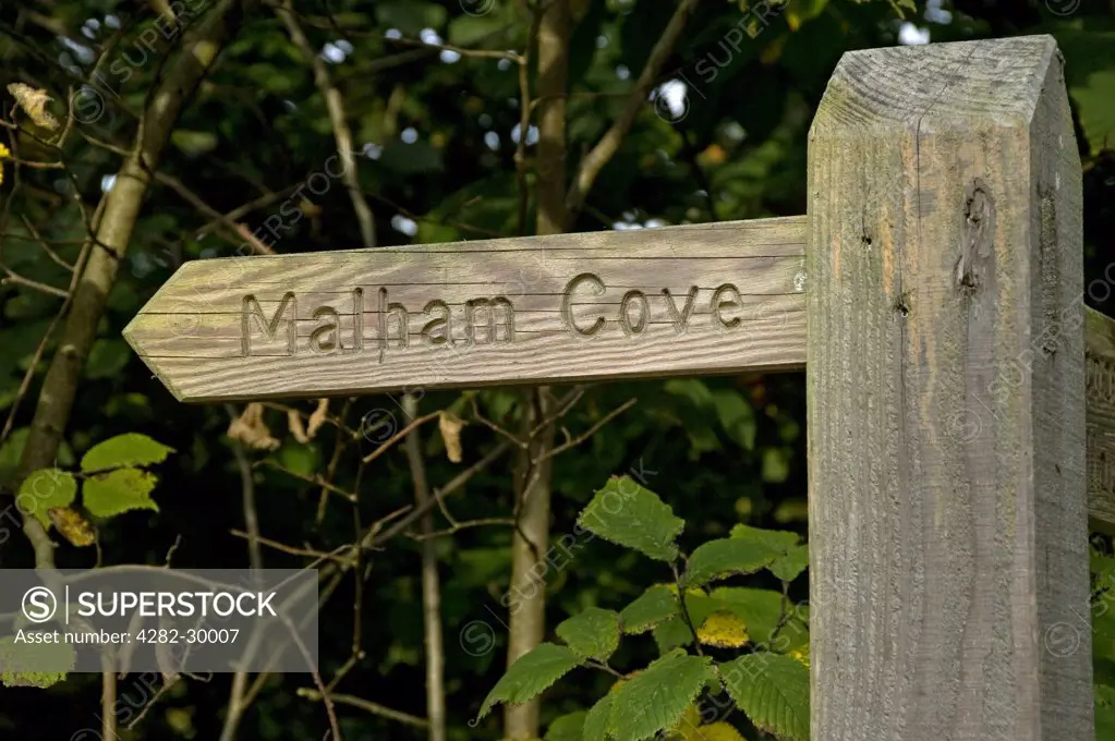 England, North Yorkshire, Malhamdale. Wooden signpost pointing to Malham Cove.