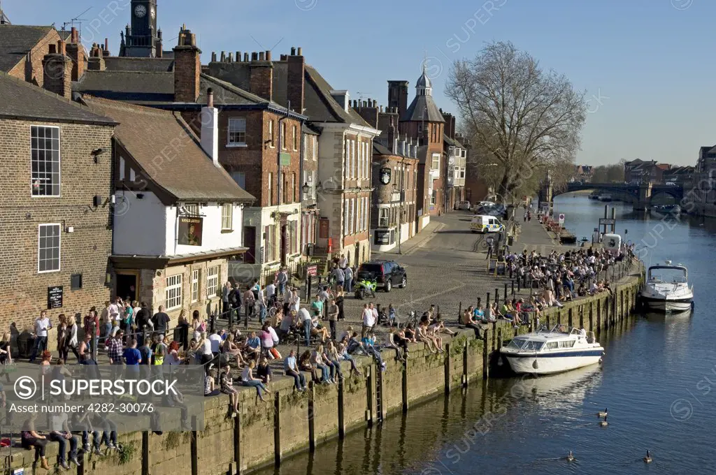 England, North Yorkshire, York. People relaxing along the banks of the River Ouse outside the Kings Arms at King's Staith.