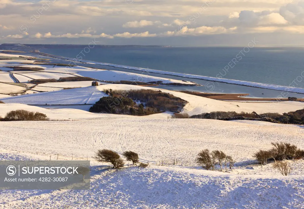 England, Dorset, Abbotsbury. View of snow-covered hills around Abbotsbury, with St Catherine's Chapel, the Fleet and Chesil Bank in the background.