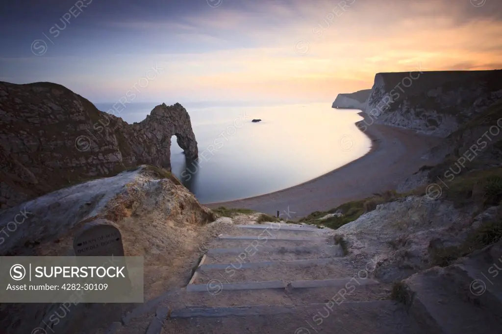 England, Dorset, Durdle Door. Steep steps leading down to the beach by Durdle Door, a natural Limestone arch near Lulworth Cove, part of the UNESCO Jurassic Coast.