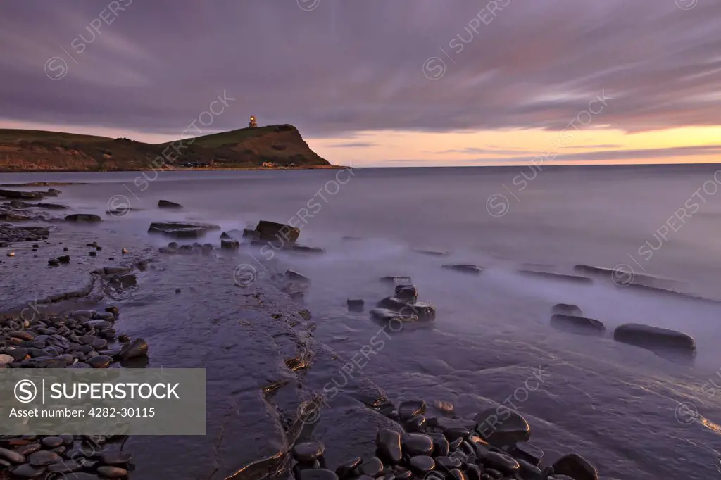 England, Dorset, Kimmeridge Bay. View over rocky ledges in Kimmeridge Bay towards Clavell Tower, a Tuscan style tower built in 1830 on Hen cliff on the Jurassic Coast in the Isle of Purbeck.