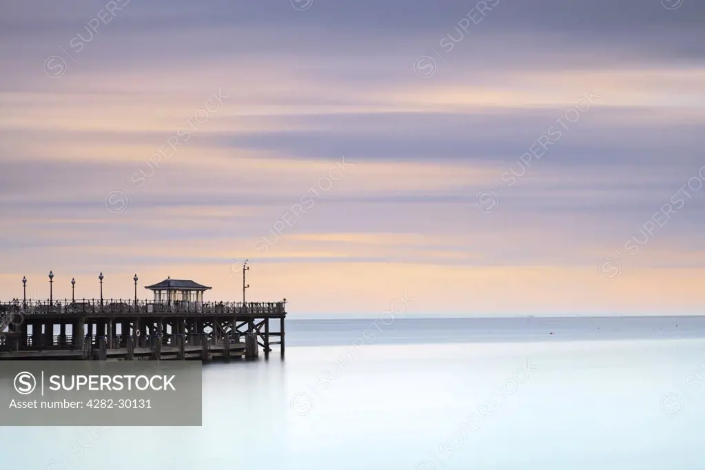 England, Dorset, Swanage. The Victorian pier at Swanage, jutting out into the sea, in early morning light.