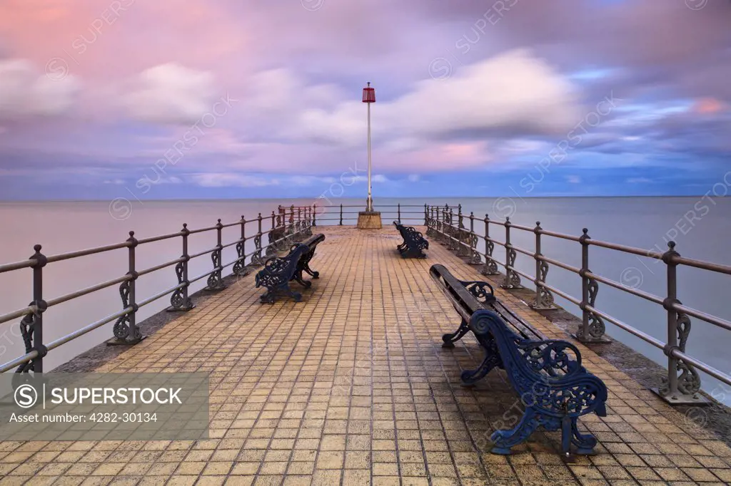England, Dorset, Swanage. View over benches on the Banjo shaped Jetty in Swanage Bay.