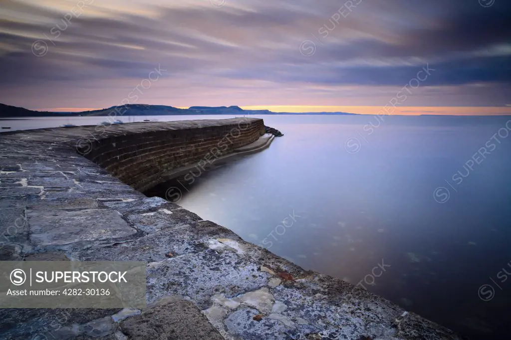 England, Dorset, Lyme Regis. Sunrise over 'The Cobb', a harbour wall that allowed Lyme Regis to become a major port from the 13th century onwards.