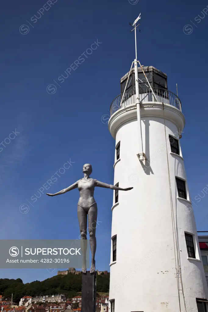 England, North Yorkshire, Scarborough. The Diving Belle by Craig Knowles next to the Lighthouse on Scarborough's West Pier.