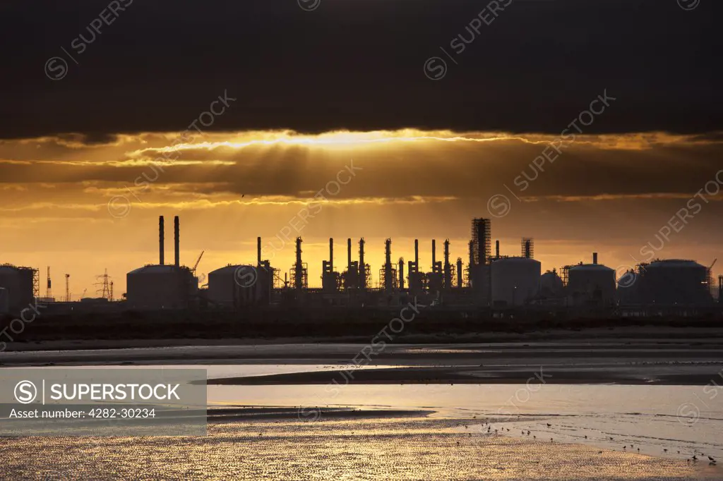 England, Redcar & Cleveland, Teesmouth. Sunset over an oil refinery at Teesmouth on the Tees estuary.