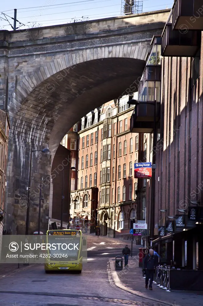 England, Tyne and Wear, Newcastle upon Tyne. A Quaylink bus travelling along Side under a railway arch.
