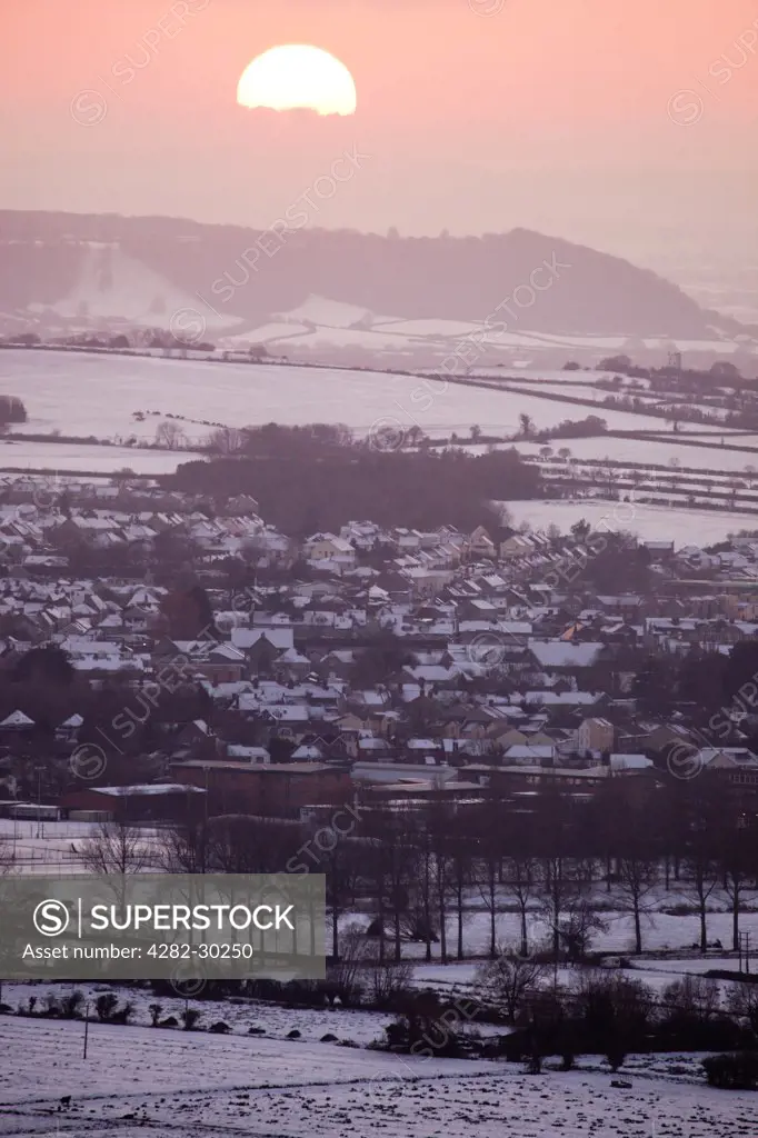 England, Somerset, Glastonbury. Snow covering the town of Glastonbury and surrounding countryside at sunset.
