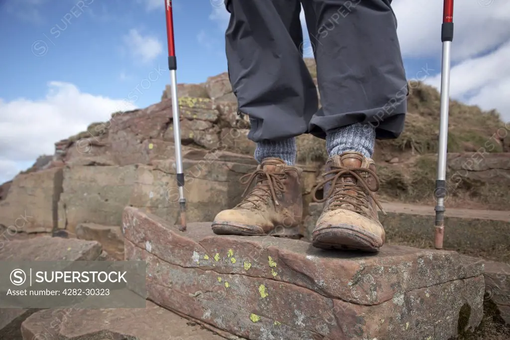 England, Powys, Pen Y Fan. Close-up of a walkers boots and poles standing on Pen Y Fan Mountain, the highest peak in South Wales.
