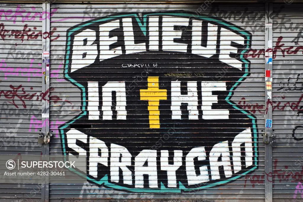 England, London, Shoreditch. 'Believe in the Spraycan' graffiti on a Shoreditch shop shutter.