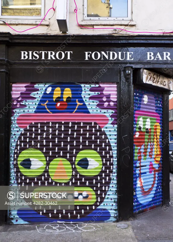 England, London, Shoreditch. Colourful pictures painted on the shutters of Bistrot Fondue Bar in the East End of London.