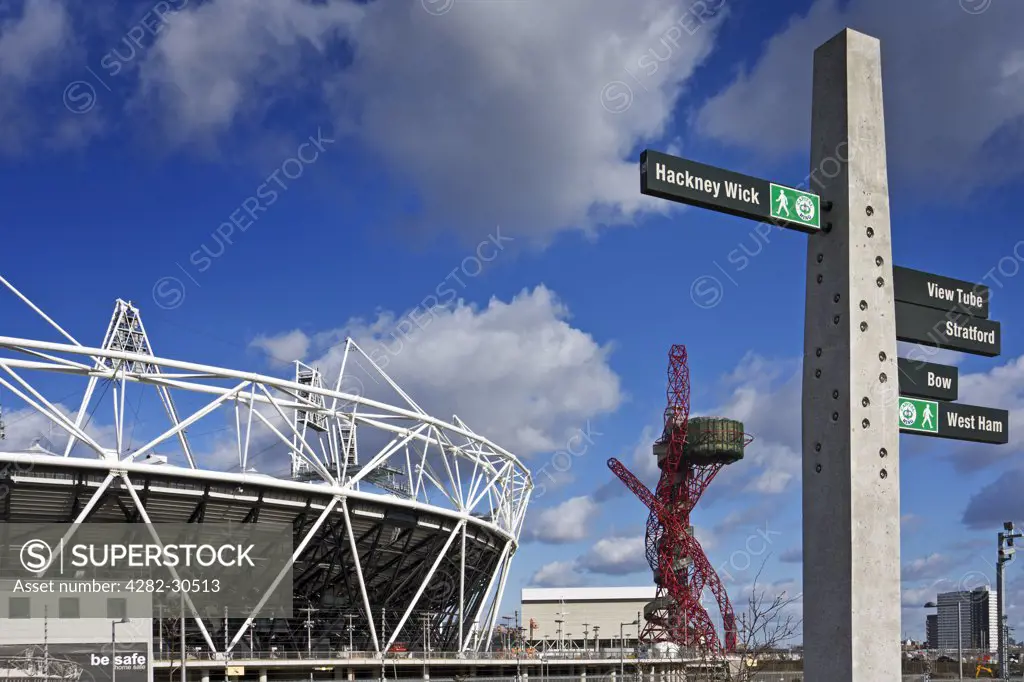 England, London, Stratford. The Olympic Stadium, ArcelorMittal Orbit and a directional signpost.