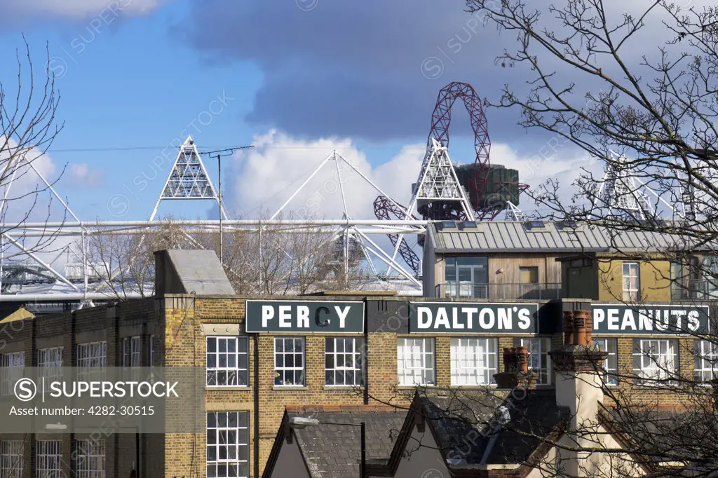 England, London, Stratford. The former Percy Dalton Peanut factory with the top of the Olympic stadium and ArcelorMittal Orbit visible in the background.