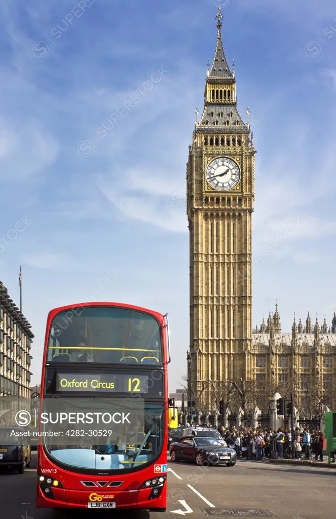 England, London, Westminster. A red London Bus opposite Big Ben, one of the most iconic landmarks in London.