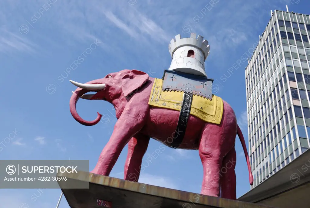England, London, Elephant and Castle. A model of a pink elephant carrying a castle outside Elephant and Castle Shopping Centre.