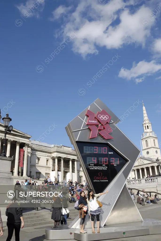 England, London, Trafalgar Square. Tourists standing by the Olympic Games London 2012 countdown clock in Trafalgar Square.