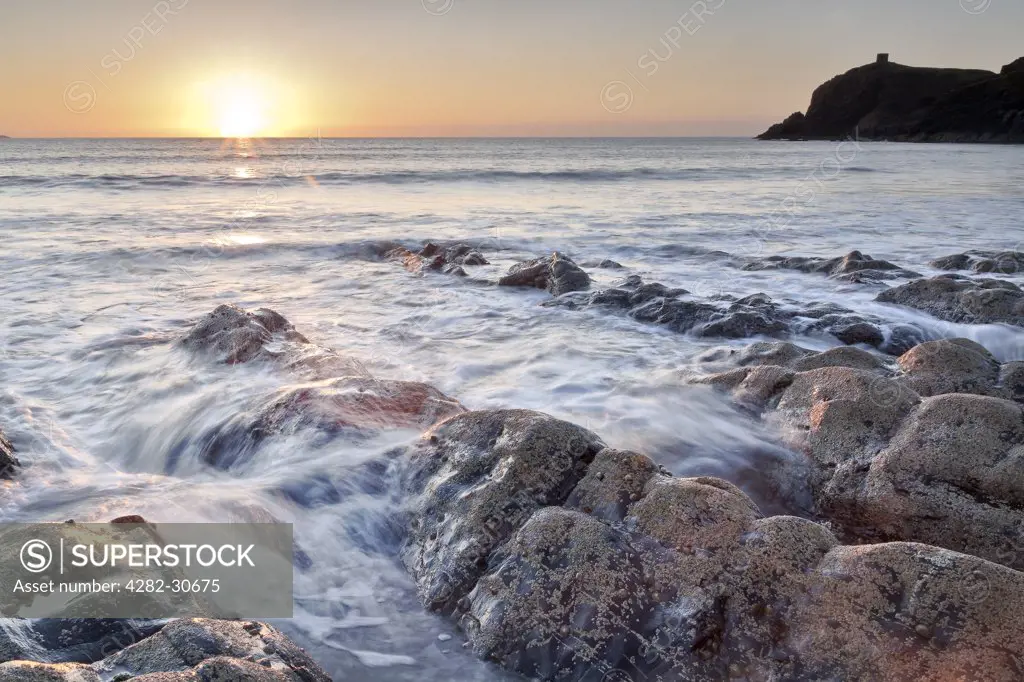 Wales, Pembrokeshire, Abereiddy. Sunset on the horizon over the sea from Abereiddy on the Pembrokeshire coast.