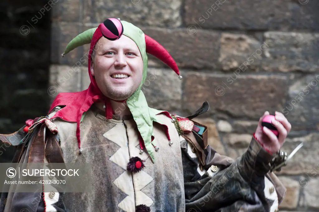 Scotland, West Lothian, Linlithgow. A jester holding a juggling ball at a medieval re-enactment based around events at Scotland's royal court in 1503. Party at the Palace was held at Linlithgow Palace as a part of Homecoming Scotland 2009.