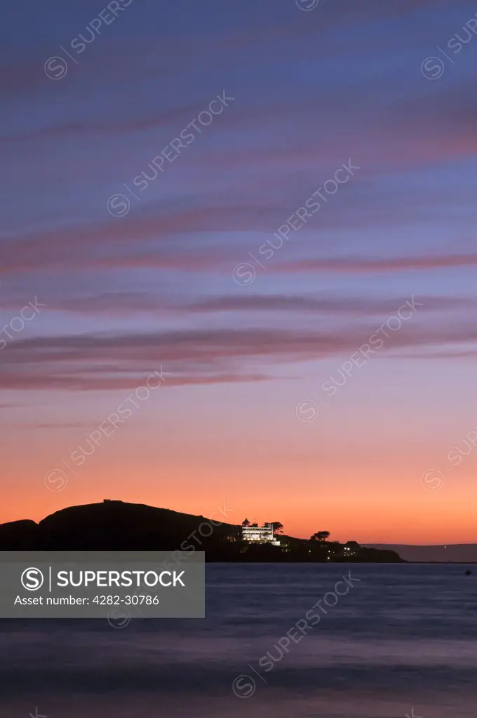 England, Devon, Bantham Beach. View from Bantham Beach towards Burgh Island silhouetted at sunset.