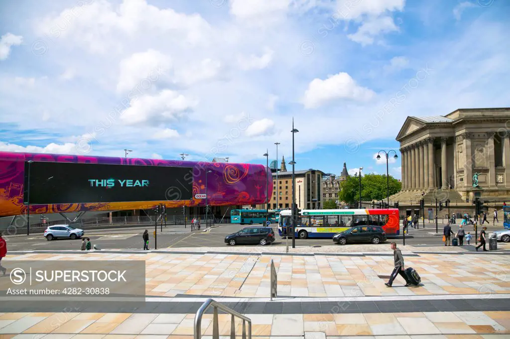 England, Merseyside, Liverpool. A view across the street to the main entrance of St Georges Hall and a large screen in Liverpool city center outside Lime Street.