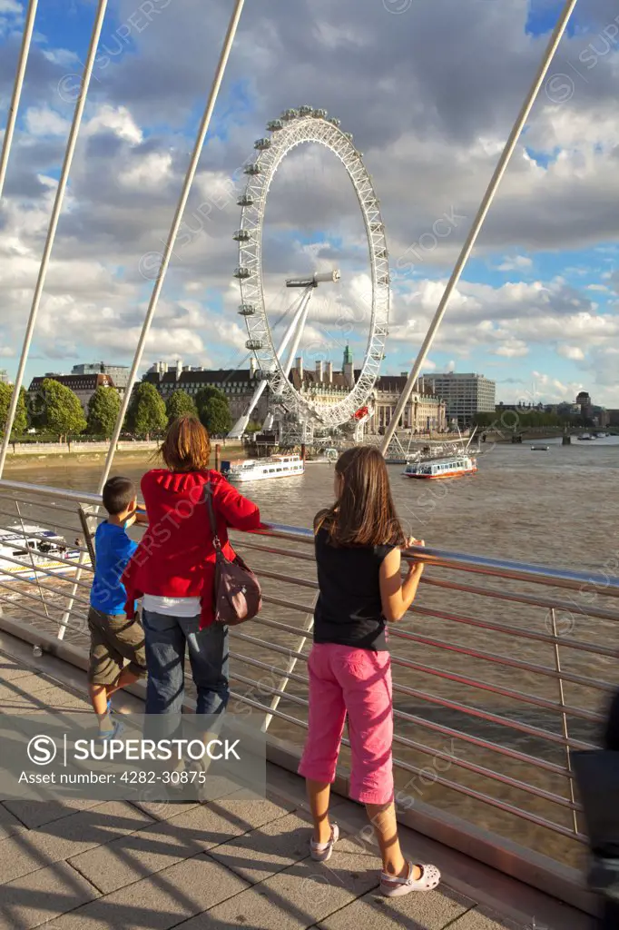 England, London, Hungerford Bridge. A mother and her children enjoy the view of the London Eye from the Hungerford Bridge over the river Thames.