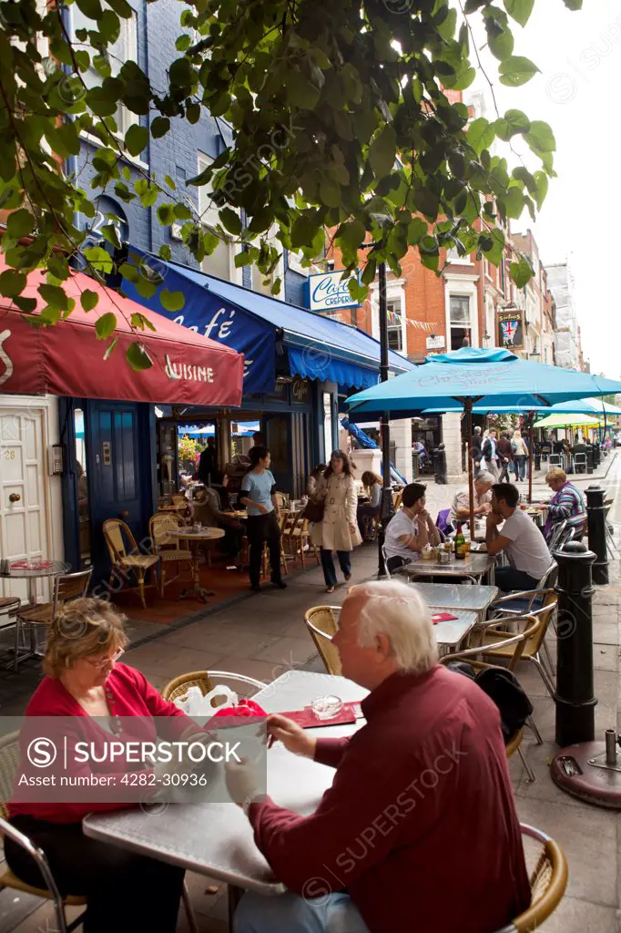 England, London, St Christopher's Place. A view of a couple of people sitting at a table at a street cafe in the City of London.