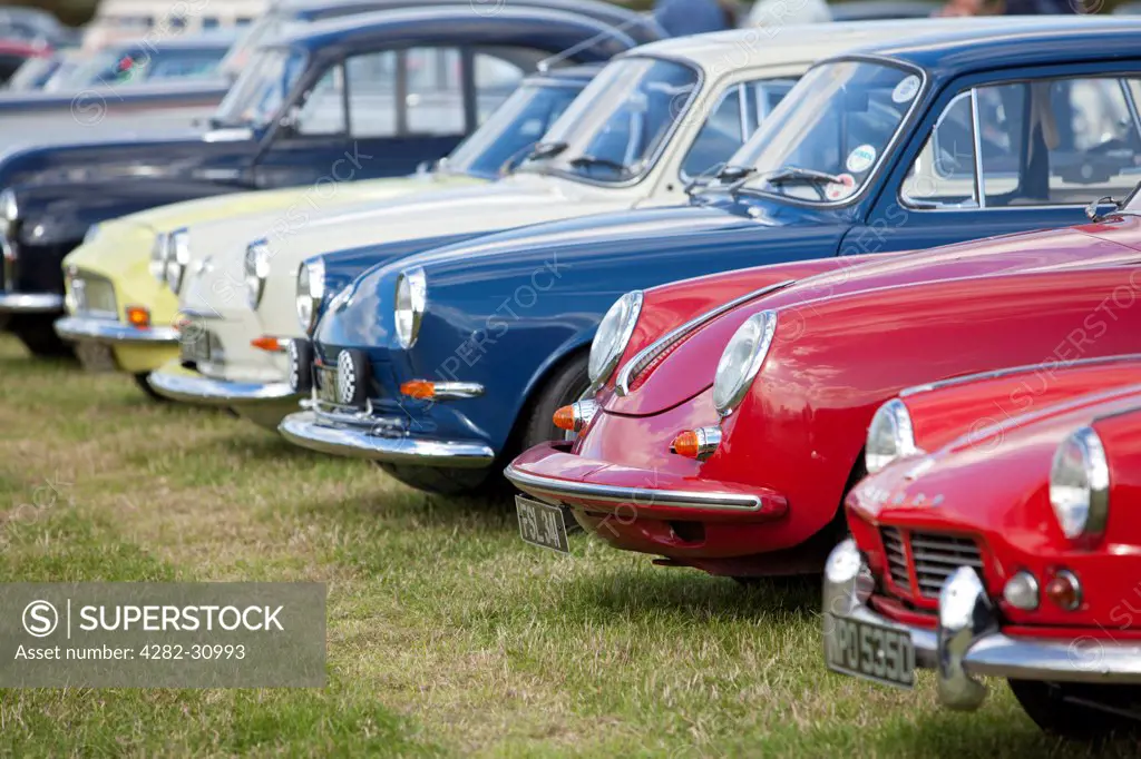 England, West Sussex, Goodwood. A series of classic cars parked at Goodwood revival.