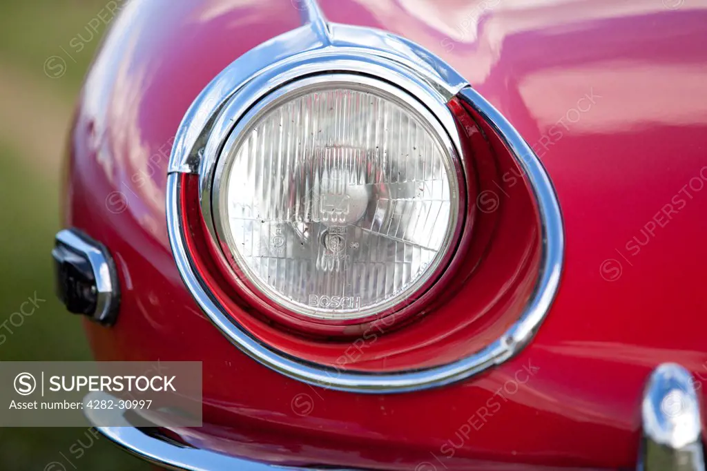 England, West Sussex, Goodwood. A close up view of the headlight of a Jaguar E Type classic car at Goodwood revival.