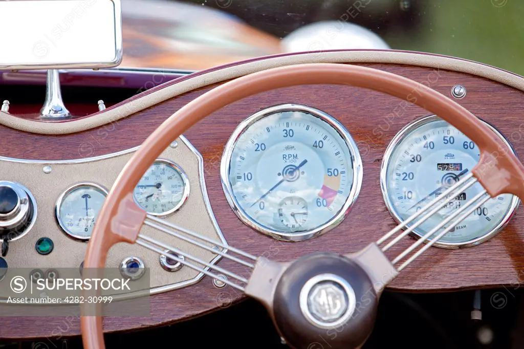 England, West Sussex, Goodwood. A close up view of the steering wheel and dashboard of a classic car at Goodwood revival.