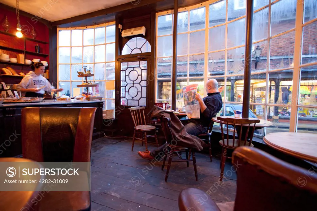 England, East Sussex, Rye. A man relaxes in the Apothecary cafe in Rye.