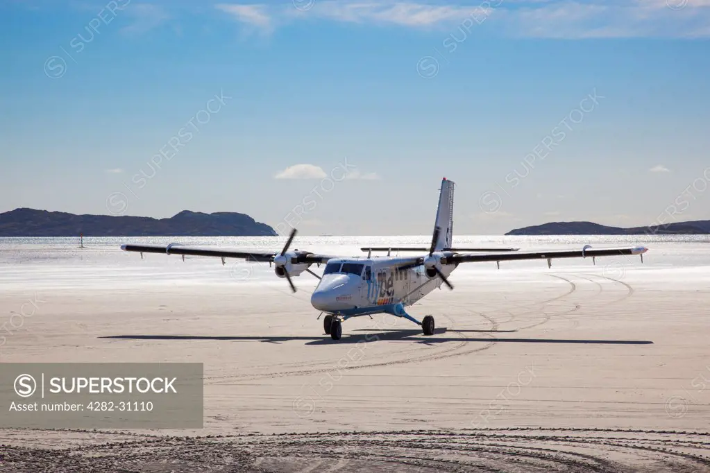 Scotland, Outer Hebrides, Barra. View of an aircraft taxiing across the beach after landing at Barra Airport.