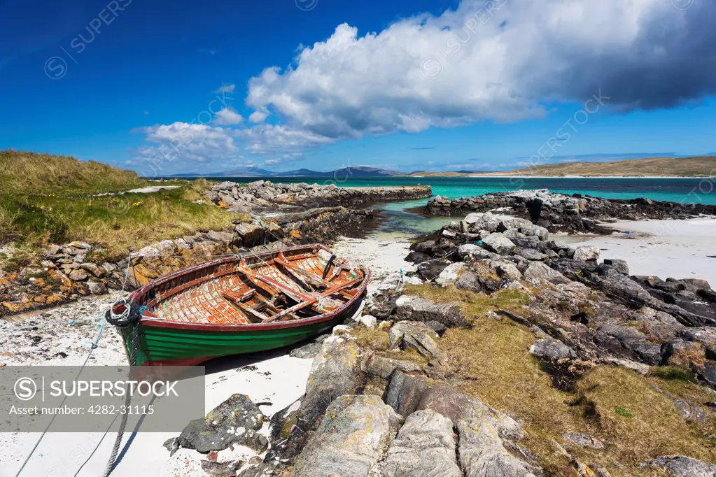Scotland, Outer Hebrides, Barra. A view of a boat moored in an inlet at Eoligarry Pier.