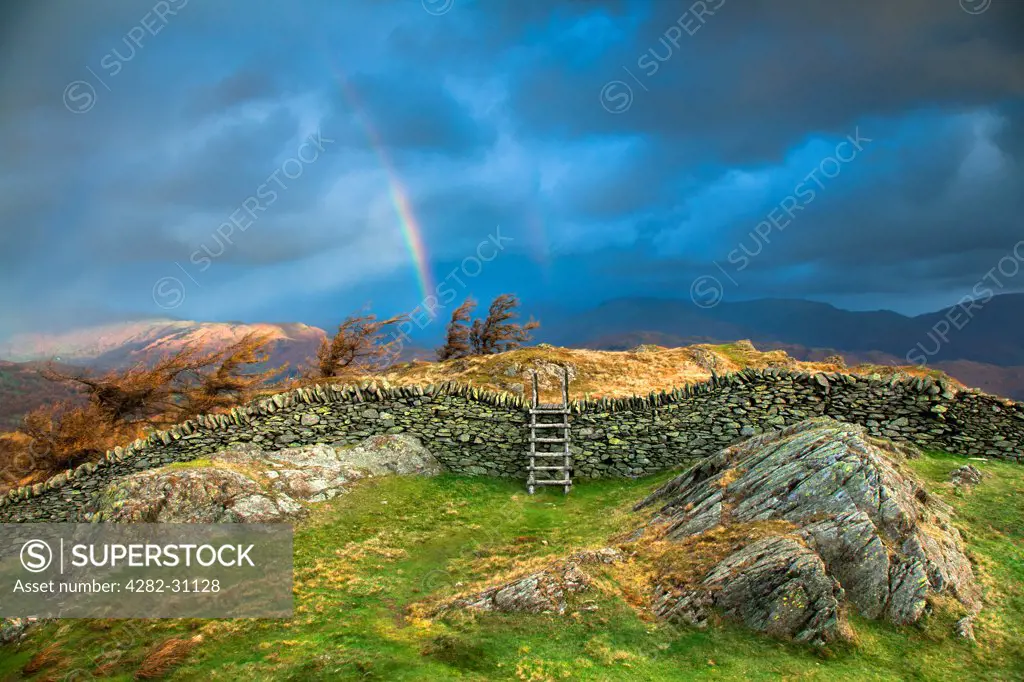 England, Cumbria, Windermere. Rainbow over Black Crag near Windermere.