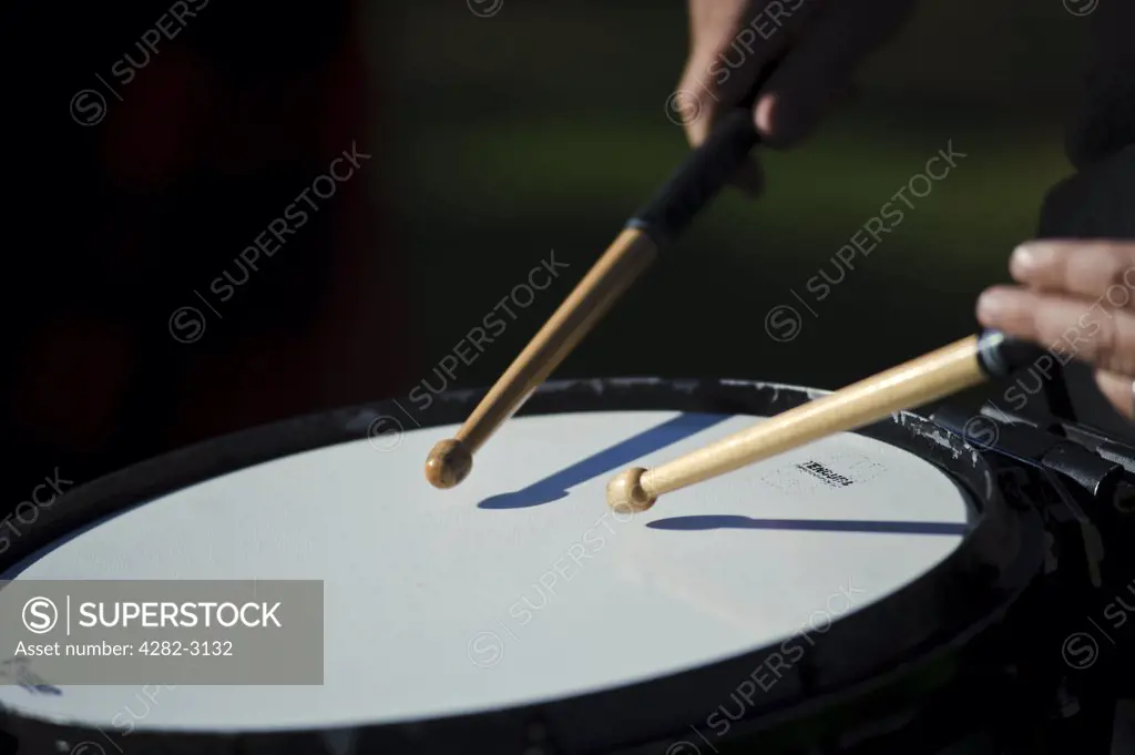Scotland, Scottish Borders, Bowhill House. Close-up of drumsticks striking a drum skin during a performance at The Muster, a regional gathering of Lowland and Border Clans on Buccleuch Estate, Selkirk.